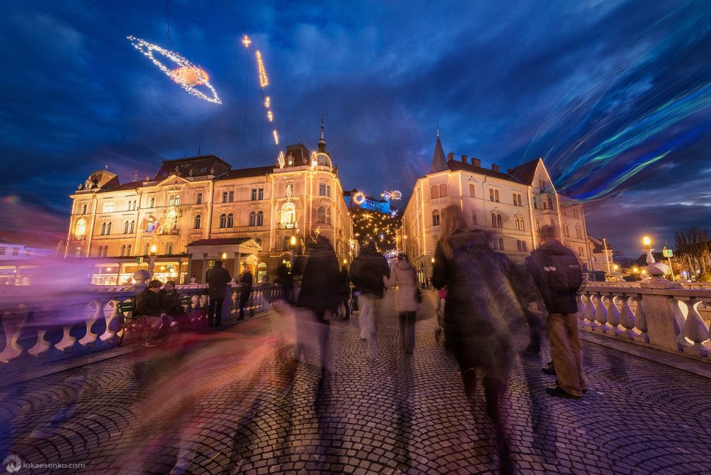 A group of people on the Triple Bridge in Ljubljana during the festive season in December