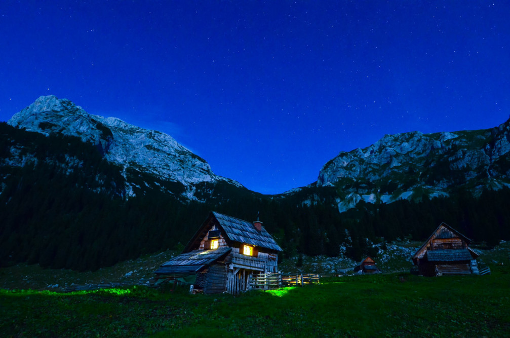 Laz Alpine pasture a.k.a. Planina v Lazu at night with wooden barns and farmhouses in traditional style