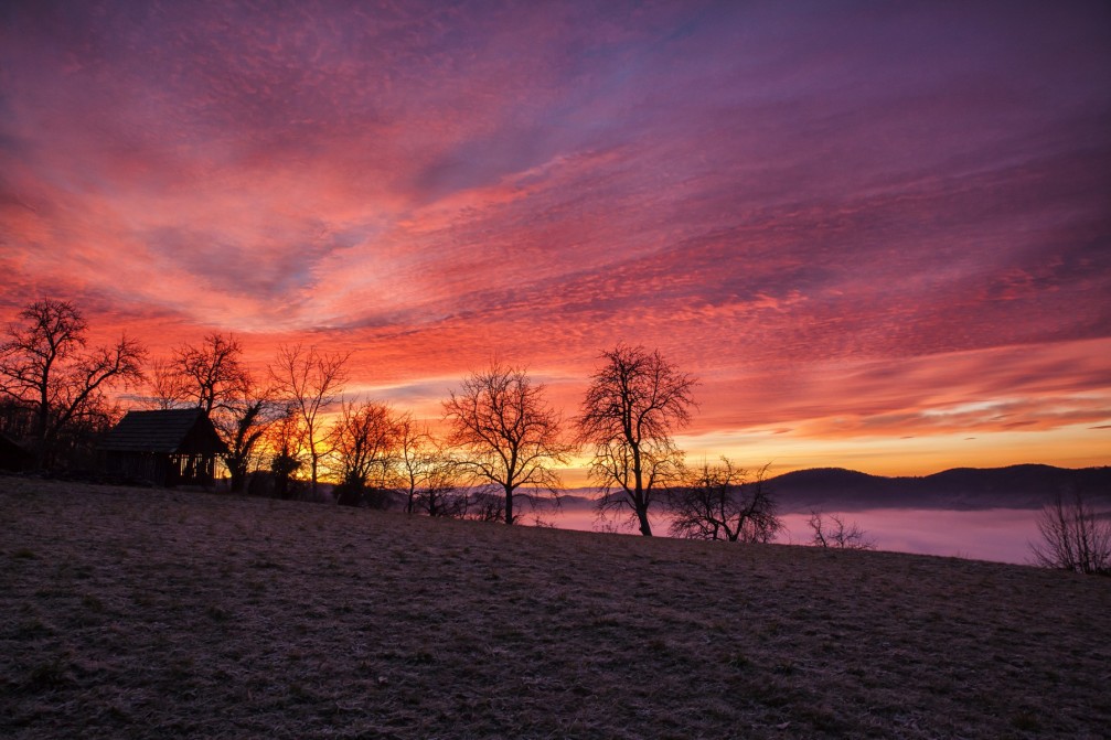 Breathtaking winter sunset with vivid colors of red and orange through purple near Dolgo Brdo, Slovenia