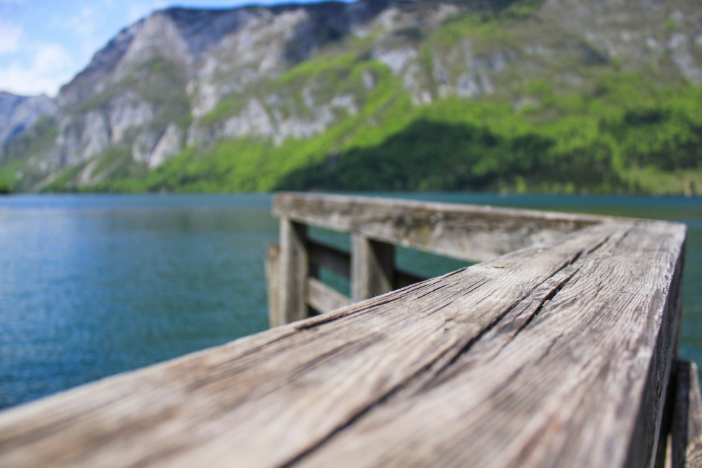A unique view over Lake Bohinj, Slovenia from a wooden pier with mountains in the background