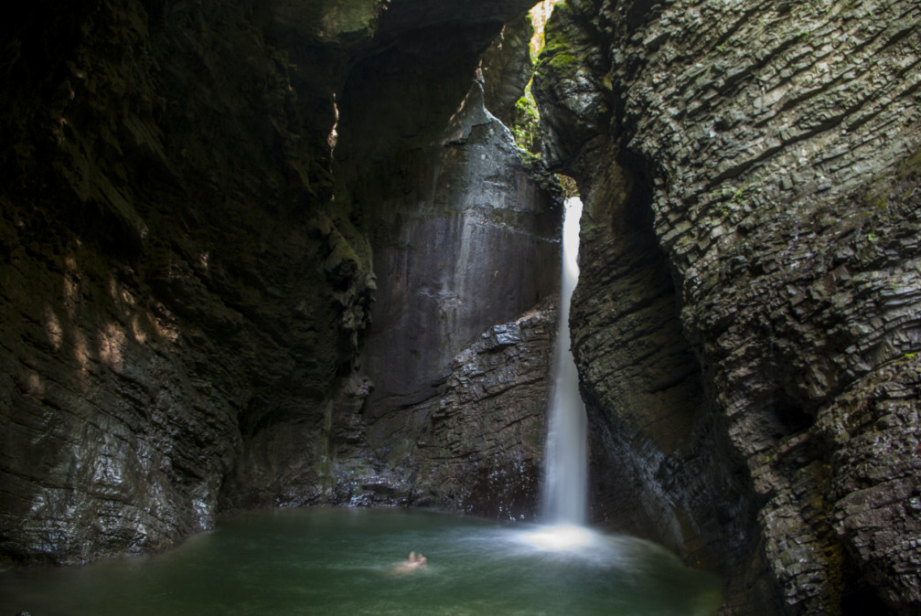 A brave man bathing and swimming in the pool at the base of the Kozjak waterfall