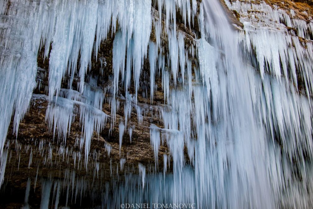 Frozen Pericnik Falls with a giant wall of icicles during the winter season