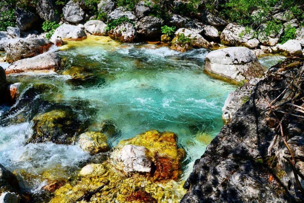 The crystal-clear emerald-green Soca river near its source in the Trenta valley