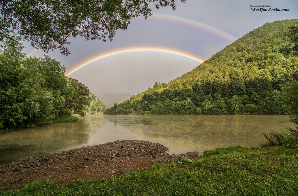 A colorful double rainbow across the Drava river near the Ozbalt village in Slovenia