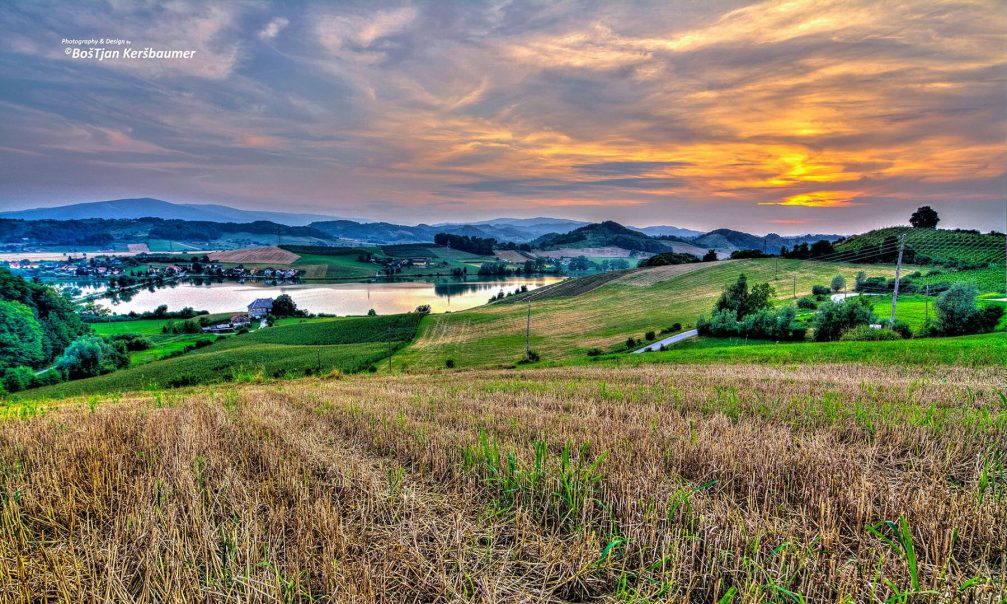 Lake Pernica surrounded by the hilly countryside of the Styria region of Slovenia at sunset