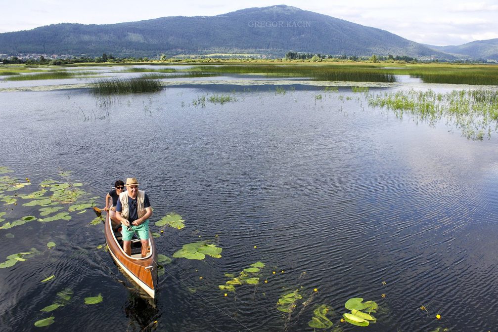 Two locals on a wooden rowing boat on Lake Cerknica in Slovenia