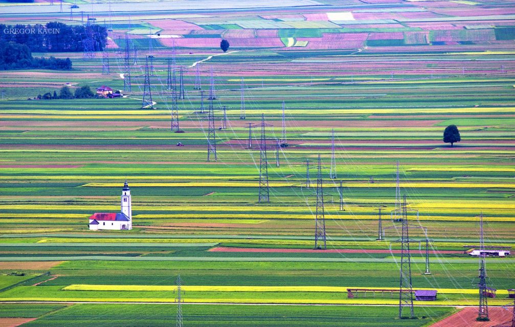 Elevated view of the Church of St. Ursula on the picturesque Sorsko Polje fields in Slovenia