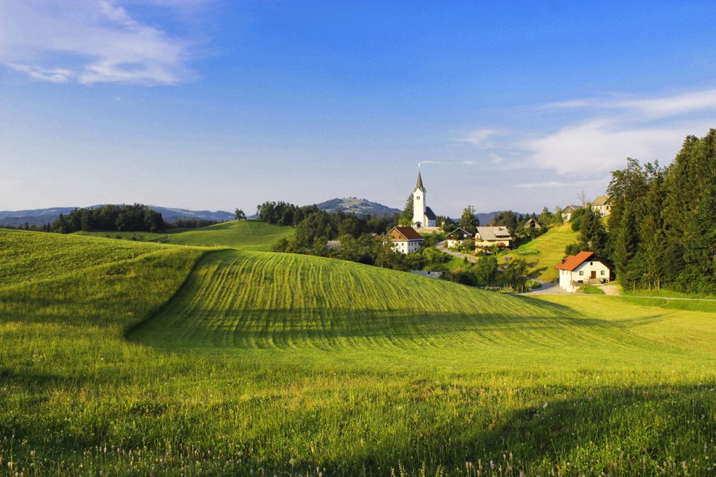 The village of Zavratec with the Church of St. Ulrich in the hills of western Slovenia