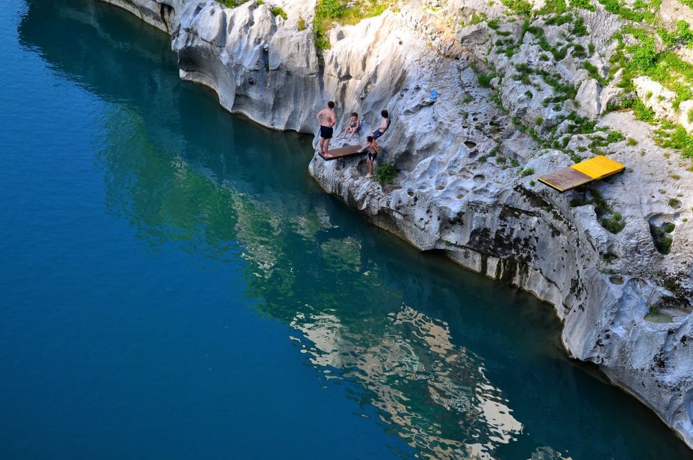 A man preparing to dive into the Soca River at Kanal Ob Soci in Slovenia