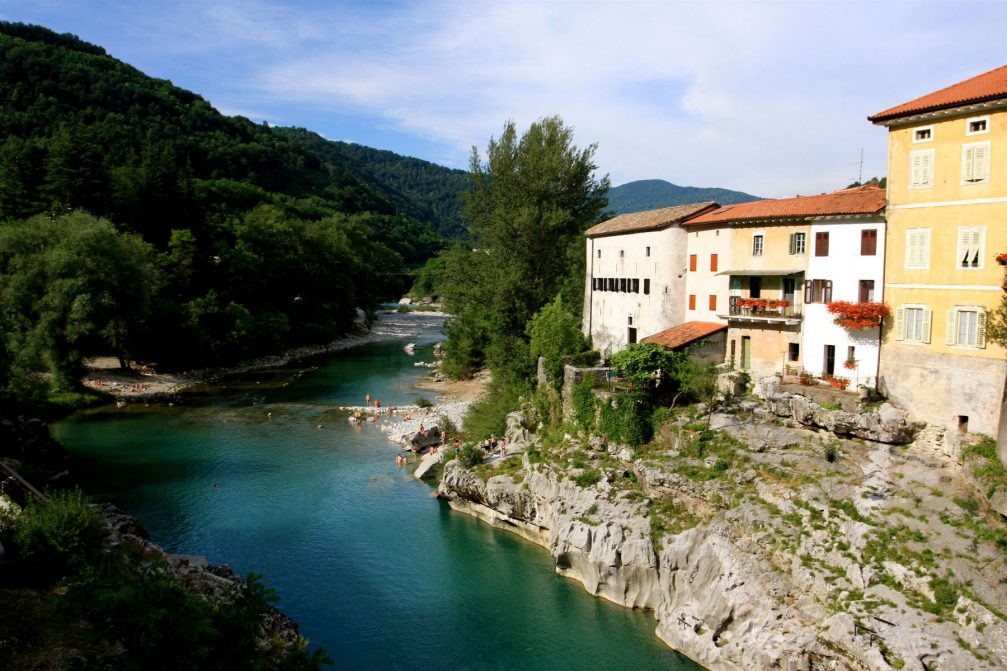 The locals and visitors in Kanal Ob Soci swimming and sunbathing in the Soca river