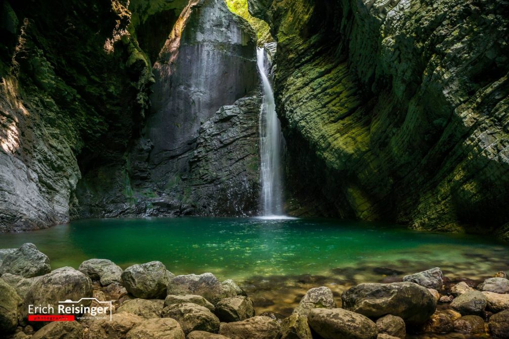 View of the beautiful Kozjak waterfall with a vast emerald green pool at its base