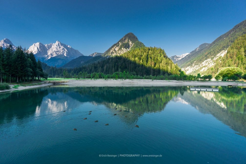 The picturesque Jasna lake surrounded by the high mountain peaks of the Julian Alps