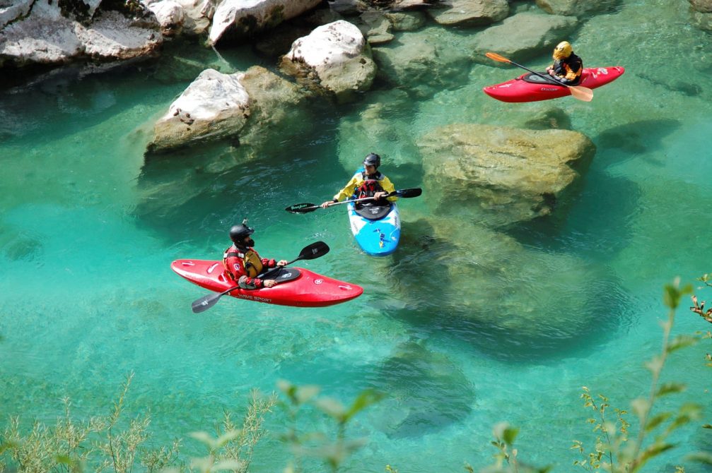 A group of kayakers on the crystal clear Soca River river in Slovenia