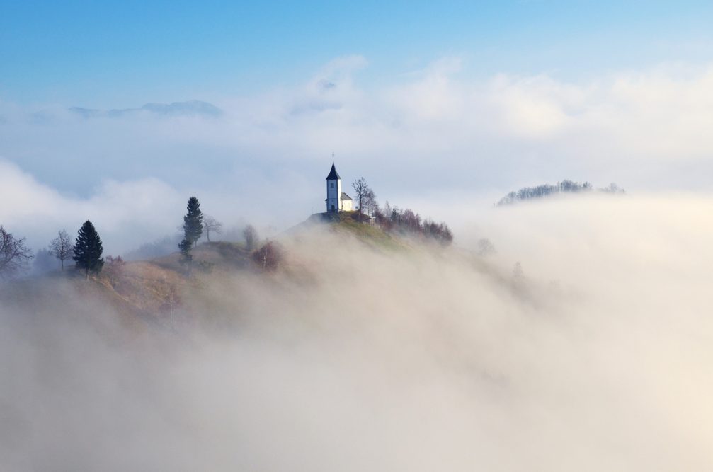 Jamnik church on a misty morning, perched on a hill on the Jelovica Plateau, Slovenia