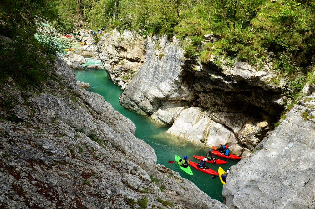 A group of water-sports enthusiasts kayaking on the Soca River in Slovenia