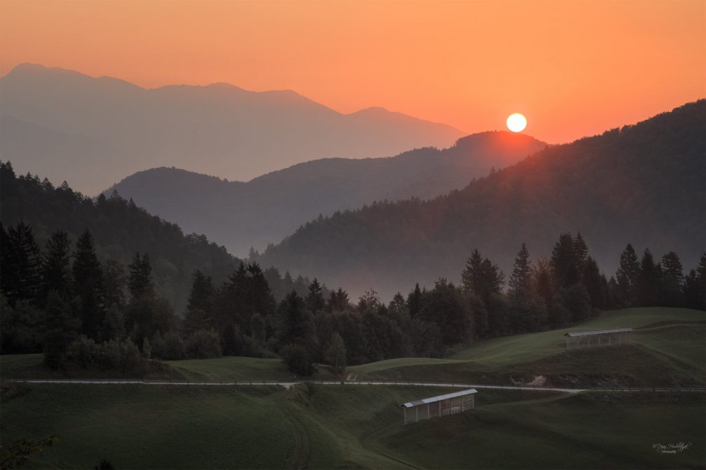 A beautiful sunset over the serene countryside of Nemilje in northwestern Slovenia