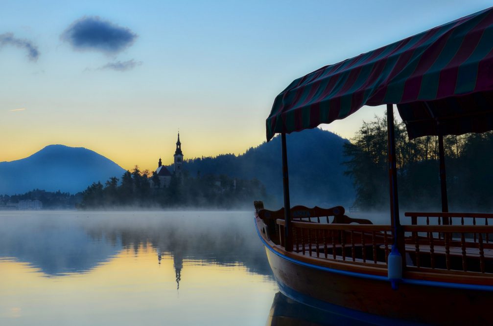 The traditional Pletna boat in Lake Bled with Bled Island in the background