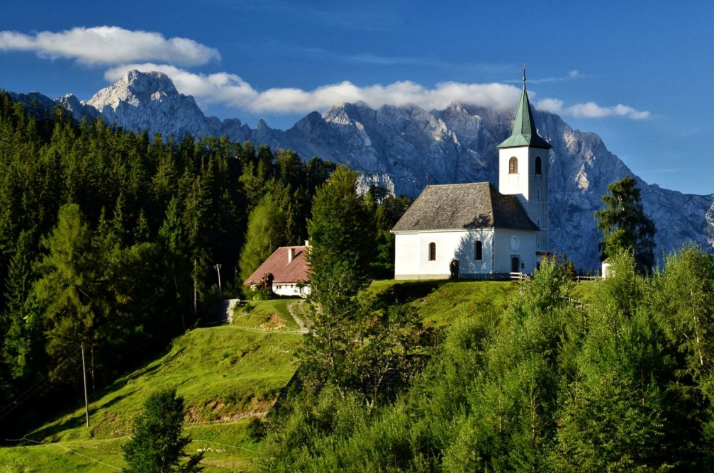 Church of the Holy Spirit in Podolseva, Slovenia with the Kamnik-Savinja Alps in the background