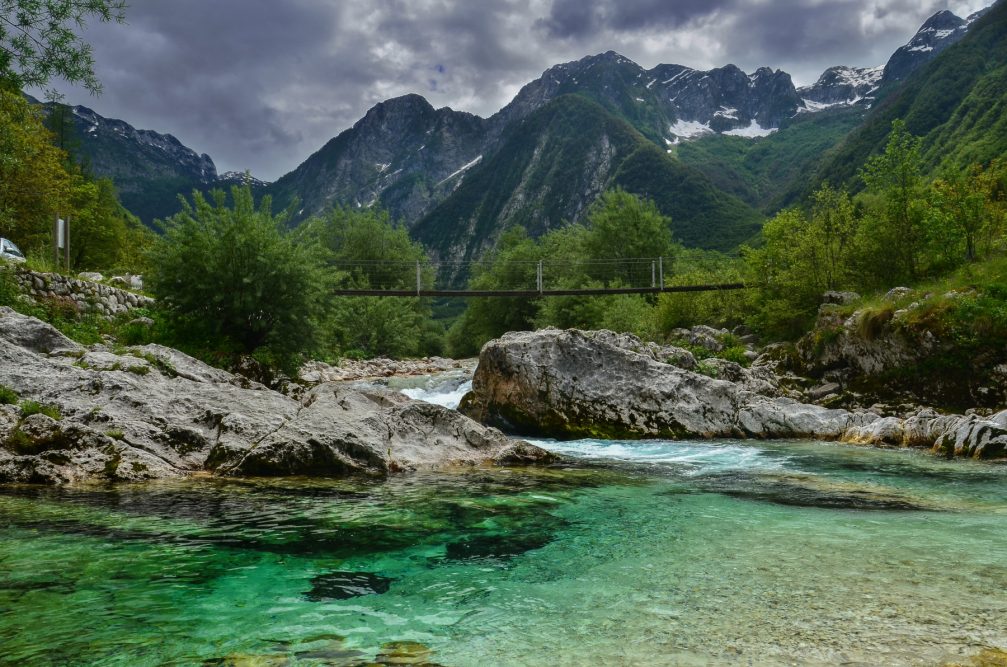 A wooden suspension footbridge across the Soca River in Slovenia