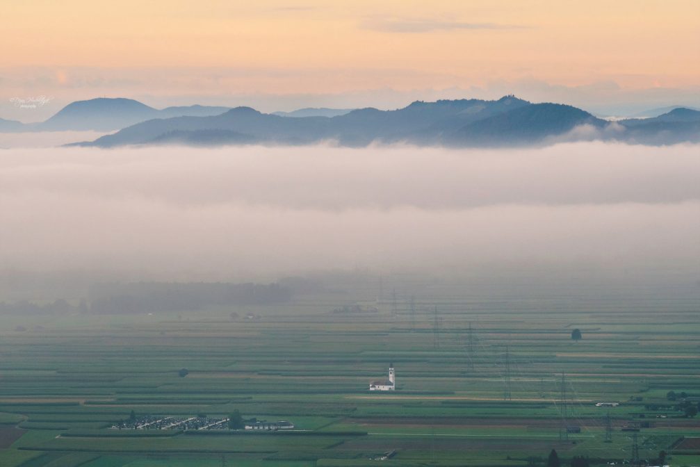 View from Smarjetna Gora towards the fields of Sorsko Polje and the Church of St. Ursula