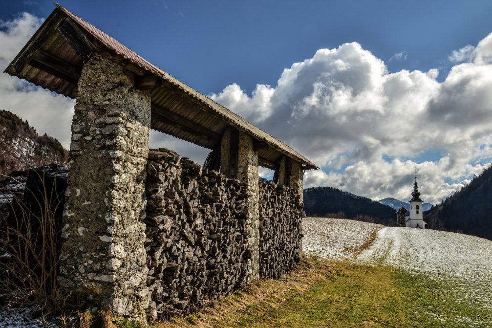 A wood pile drying in the sun under the hayrack in Spodnje Danje, Slovenia