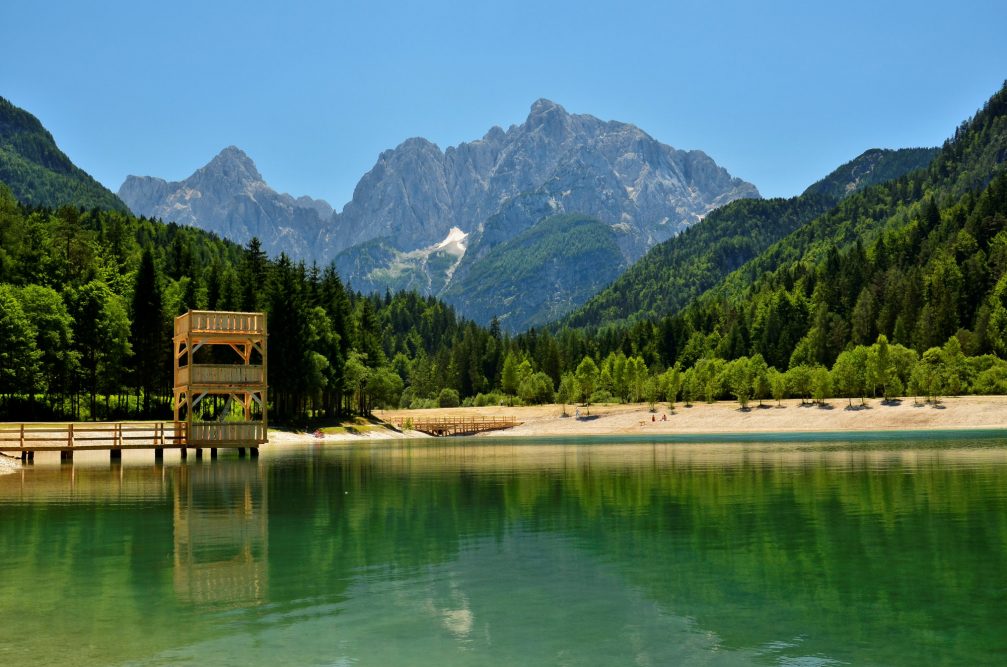 Lake Jasna in Kranjska Gora with a three-tiered wooden diving platform, resembling a castle turret