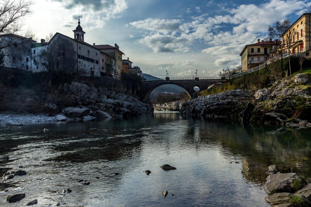 River Soca flowing under a twin-arch bridge at Kanal Ob Soci in western Slovenia