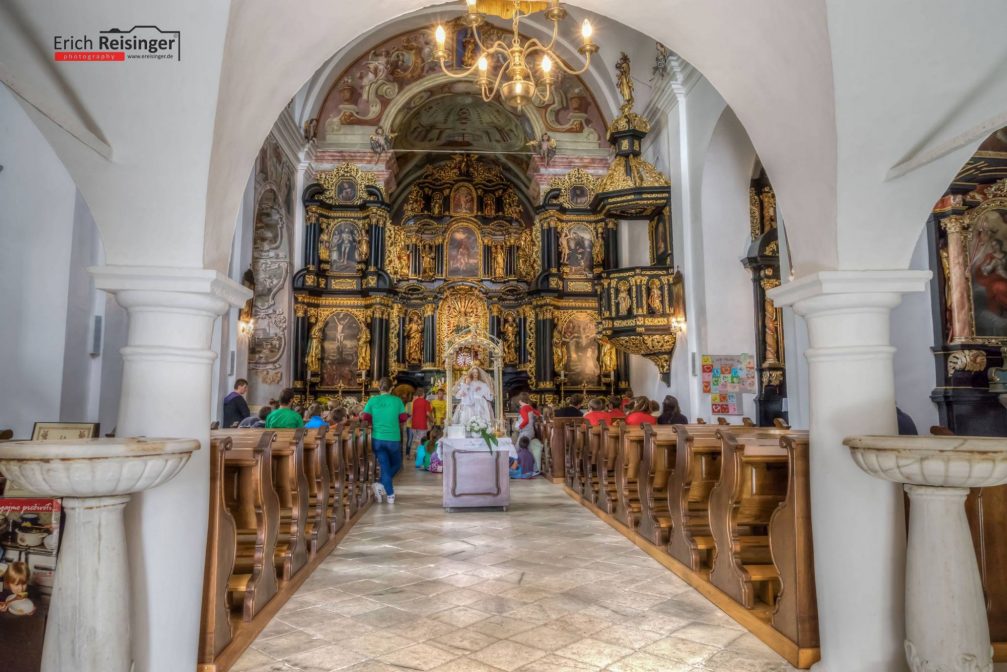 Interior of the Baroque church with a large golden altar, part of the Olimje Monastery