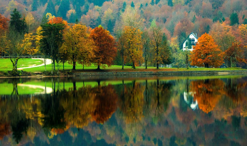 A glass-like lake surface of Lake Bohinj beautifully reflecting the surrounding landscape