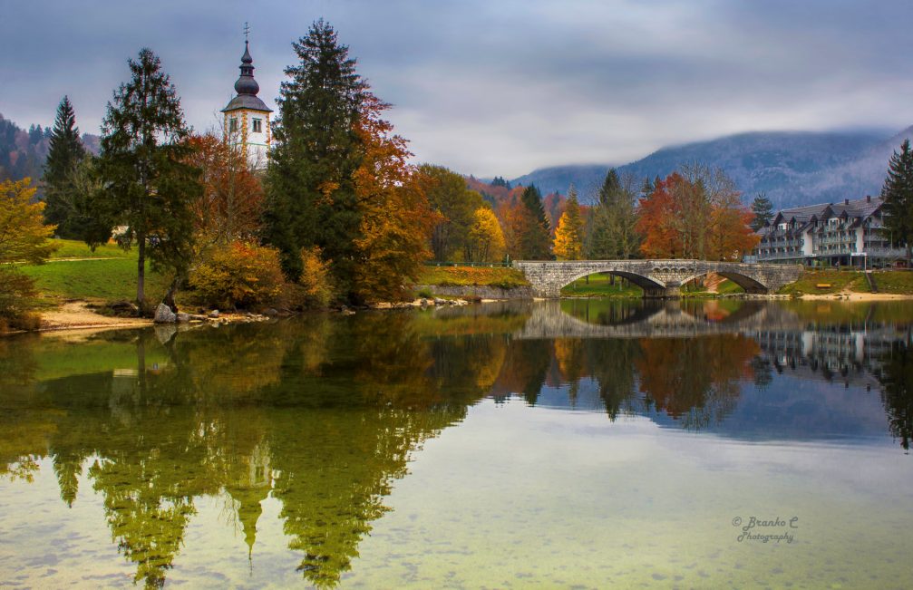 Lake Bohinj with the Church of St John the Baptist and an old stone bridge