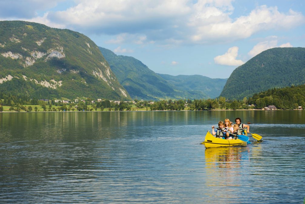 Family canoeing at Lake Bohinj in Slovenia