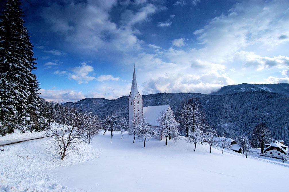 A church covered in snow in the winter in the countryside of the Koroska region of Slovenia