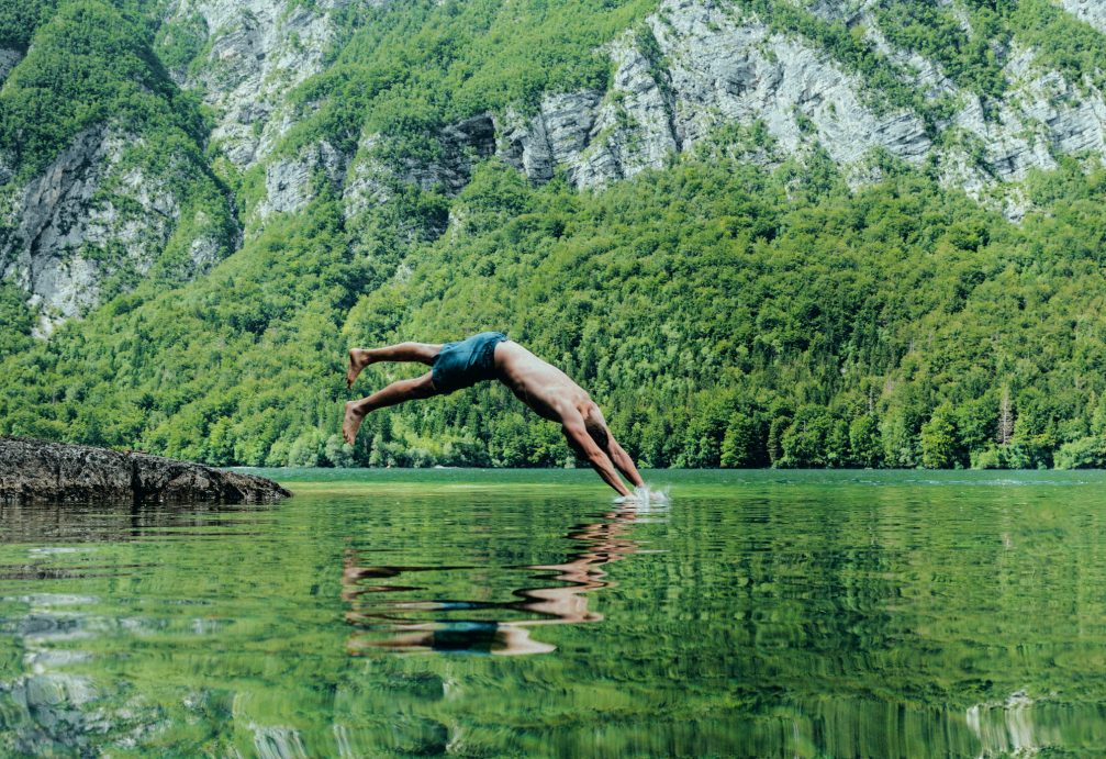 A man swimming in Lake Bohinj in Slovenia in summer