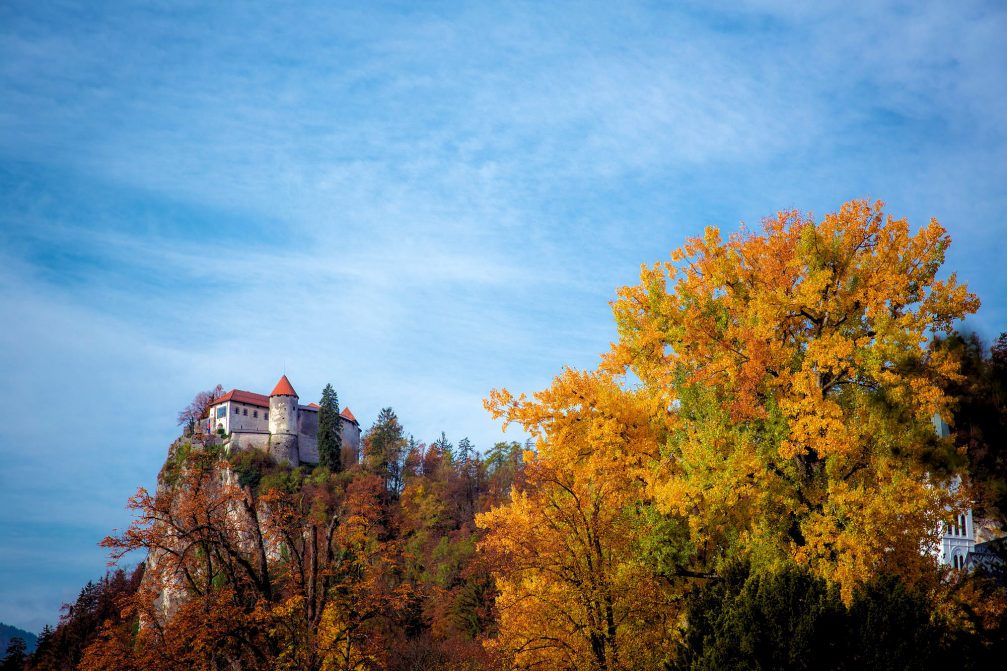 Bled Castle perched up on the cliffs above Lake Bled in autumn