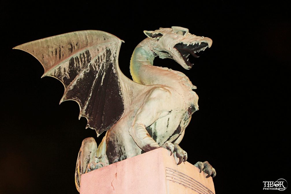 Dragon statue of sheet copper on the Dragon Bridge in Ljubljana at night