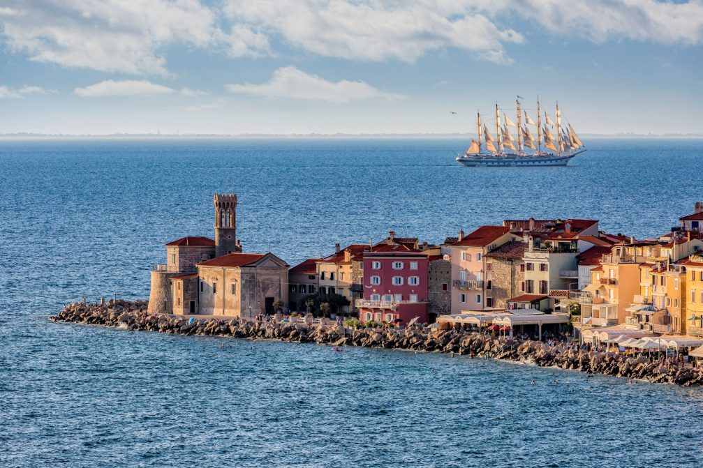 Coastal town of Piran, Slovenia with the largest full-rigged sailing ship in the world Royal Clipper passing by