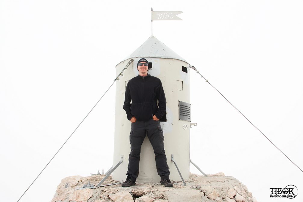 Tibor Lelkes and the Aljaz Tower on top of Mount Triglav in Slovenia