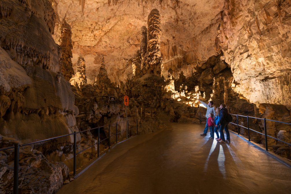 A group of people watching rock formations inside the Postojna Cave in Slovenia