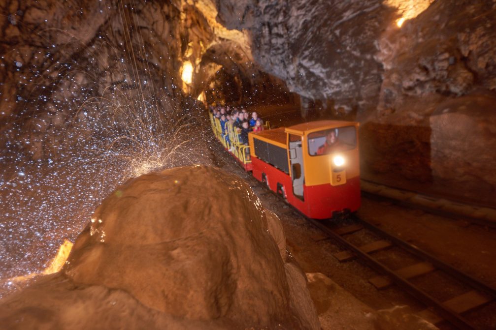 An electric train riding through Postojna Caves in Slovenia