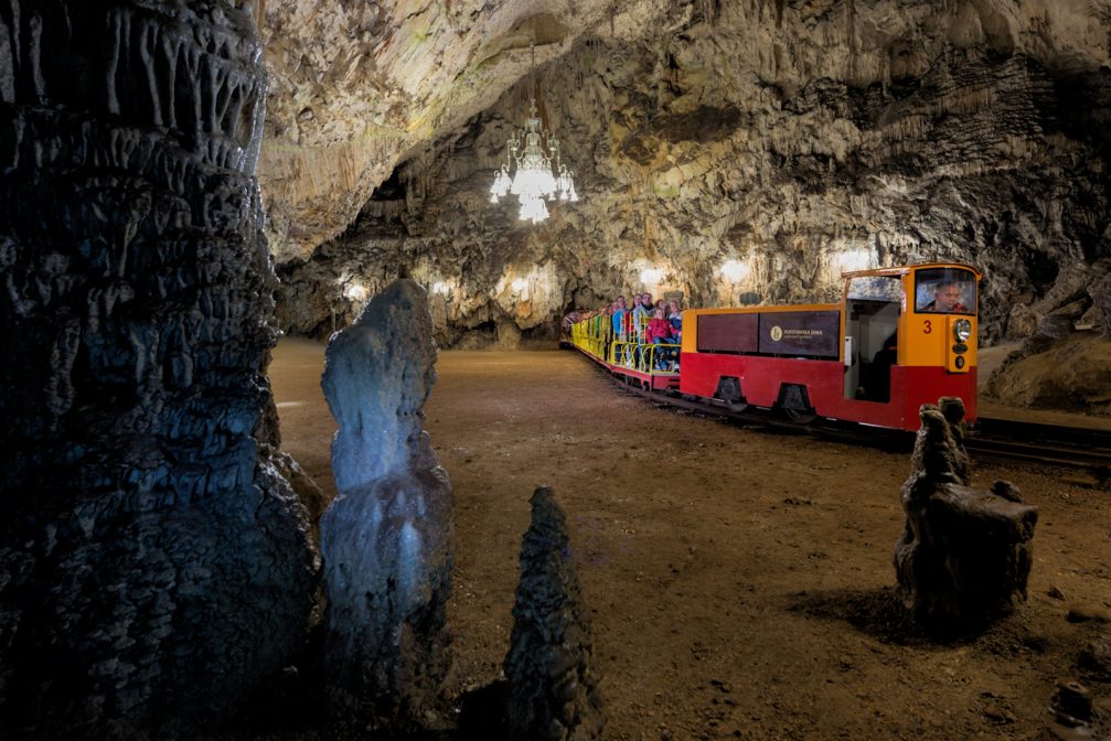 An electric train full of visitors inside Postojna Caves in Slovenia