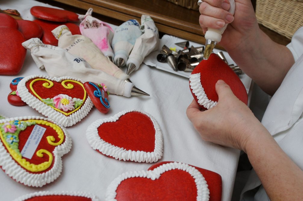 A woman decorating gingerbread hearts