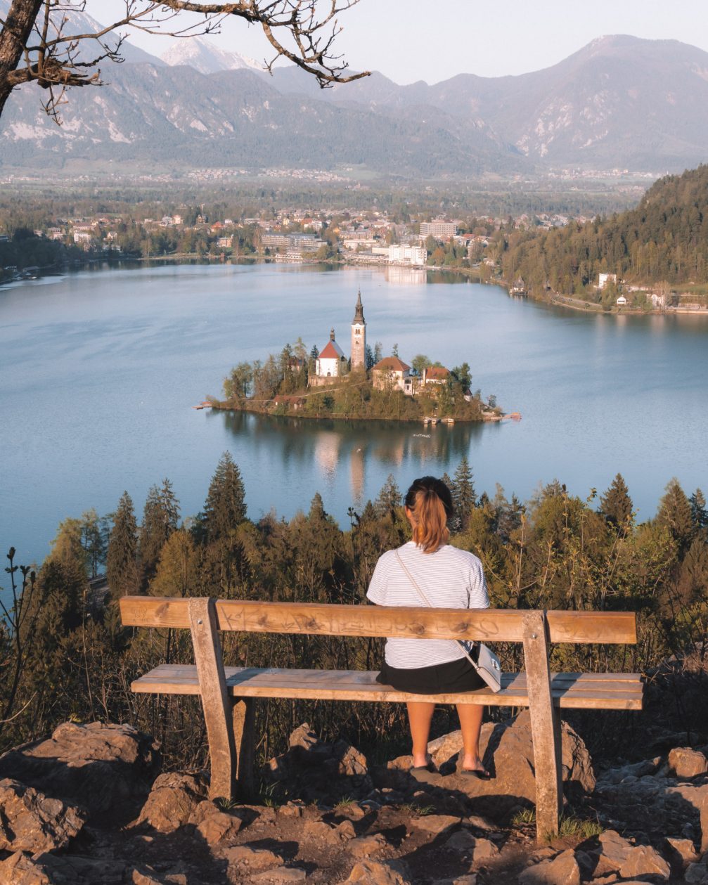 A female sitting on a bench with a view of Lake Bled in Slovenia