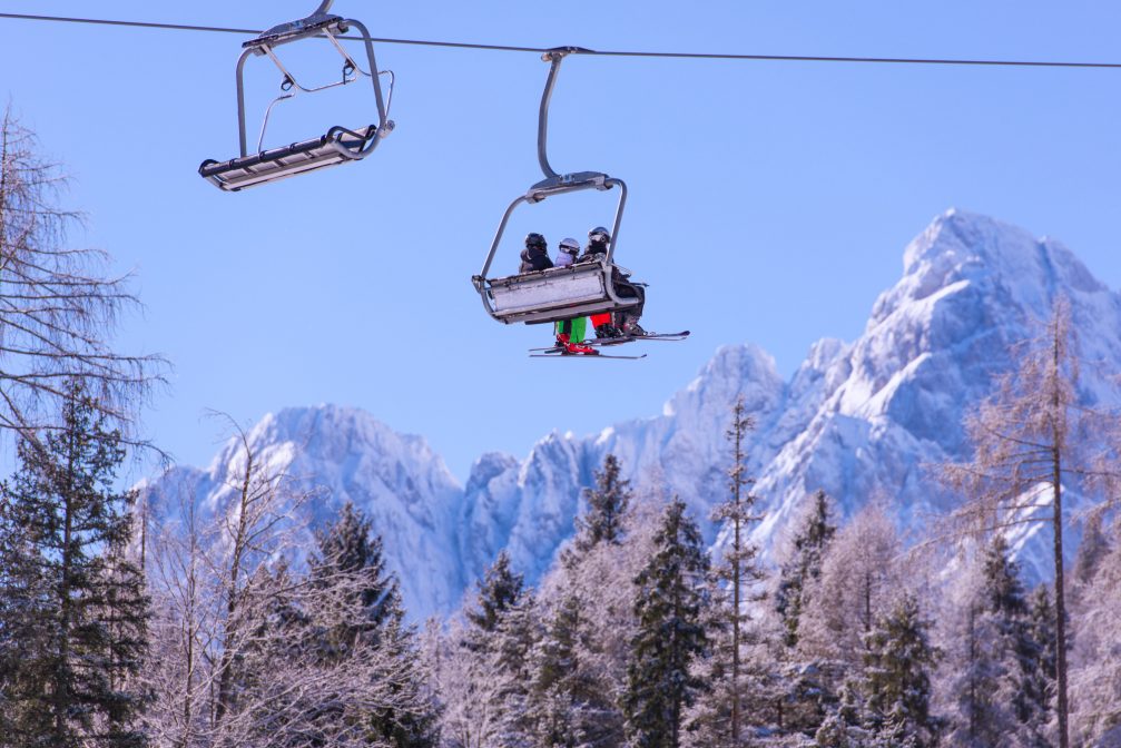 Four persons chair lift at Kranjska Gora Ski Resort with mountains of the Slovenian Alps in the background