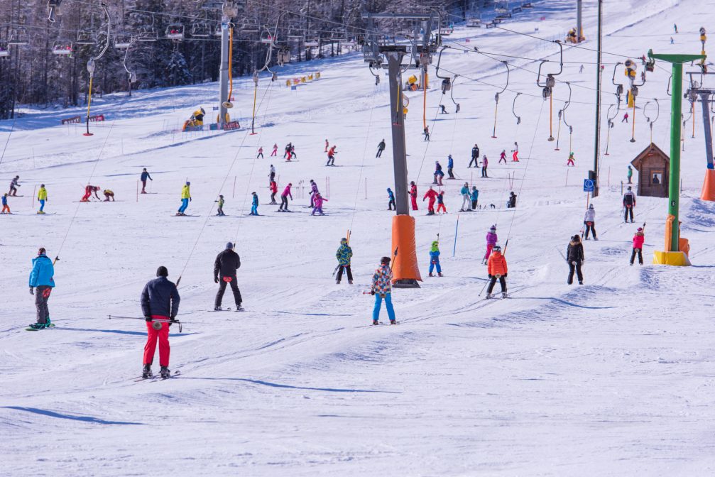 Skiers skiing on the beginner-friendly slopes of Kranjska Gora Ski Resort in Slovenia