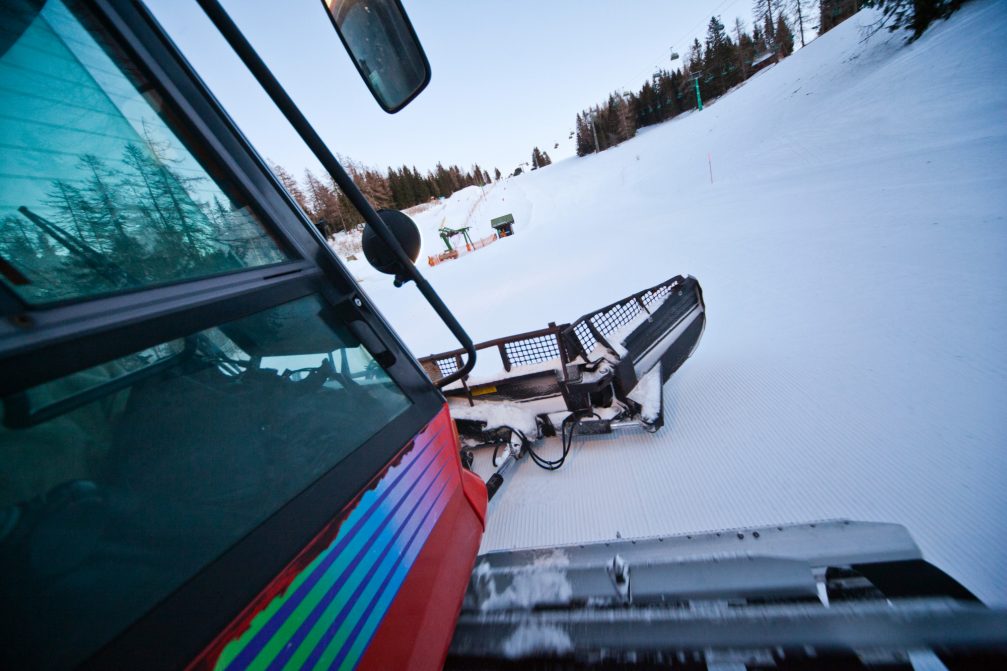 A snow groomer grooming the slopes at Cerkno Ski Resort in Slovenia