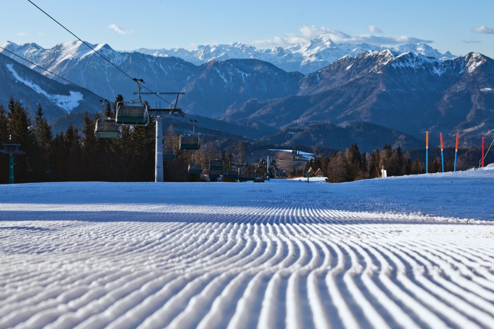 A series of parallel lines in snow made by a snow caterpillar grooming the ski runs at Cerkno Ski Resort in Slovenia