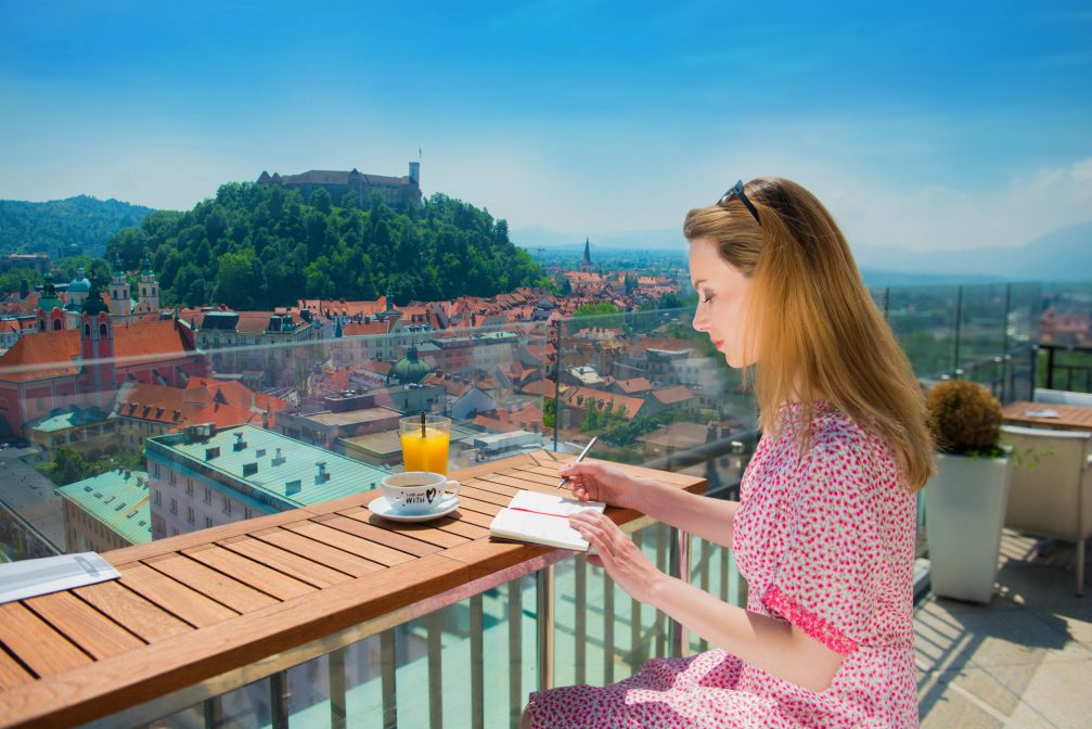 A female on the balcony with a view of Ljubljana Old Town