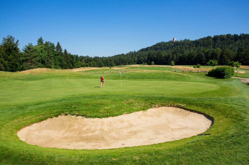 A female golfer putting at Diners CUBO Ljubljana Golf Course in Slovenia