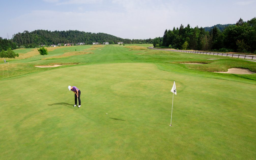 A male golfer putting at Diners CUBO Ljubljana Golf Course in Slovenia