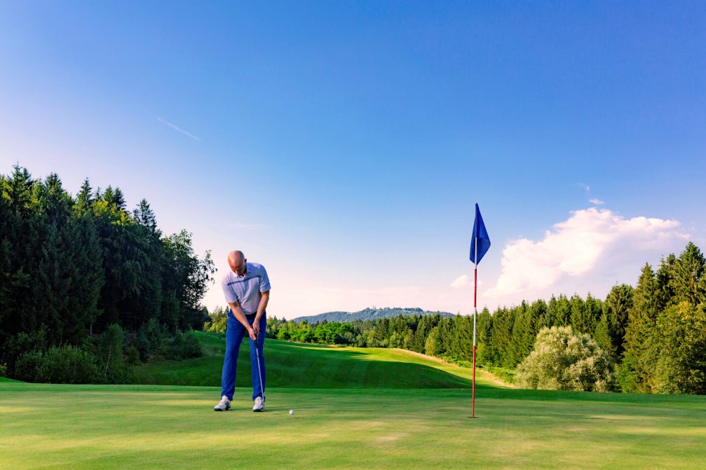 Male golfer putting at Otocec Golf Course in Slovenia